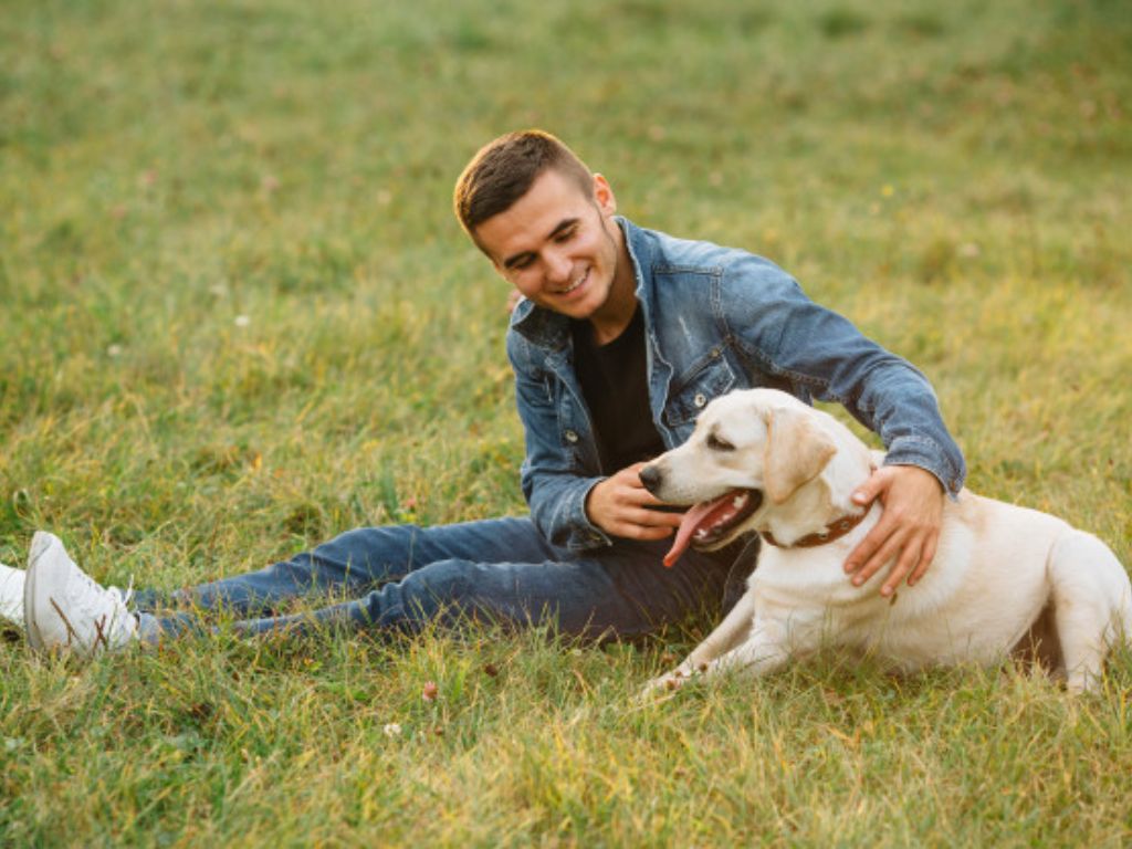 His dog. Мужчина с лабрадором. Мужчина в парке с лабрадором. Парень с собакой на природе. Человек с собакой на траве.